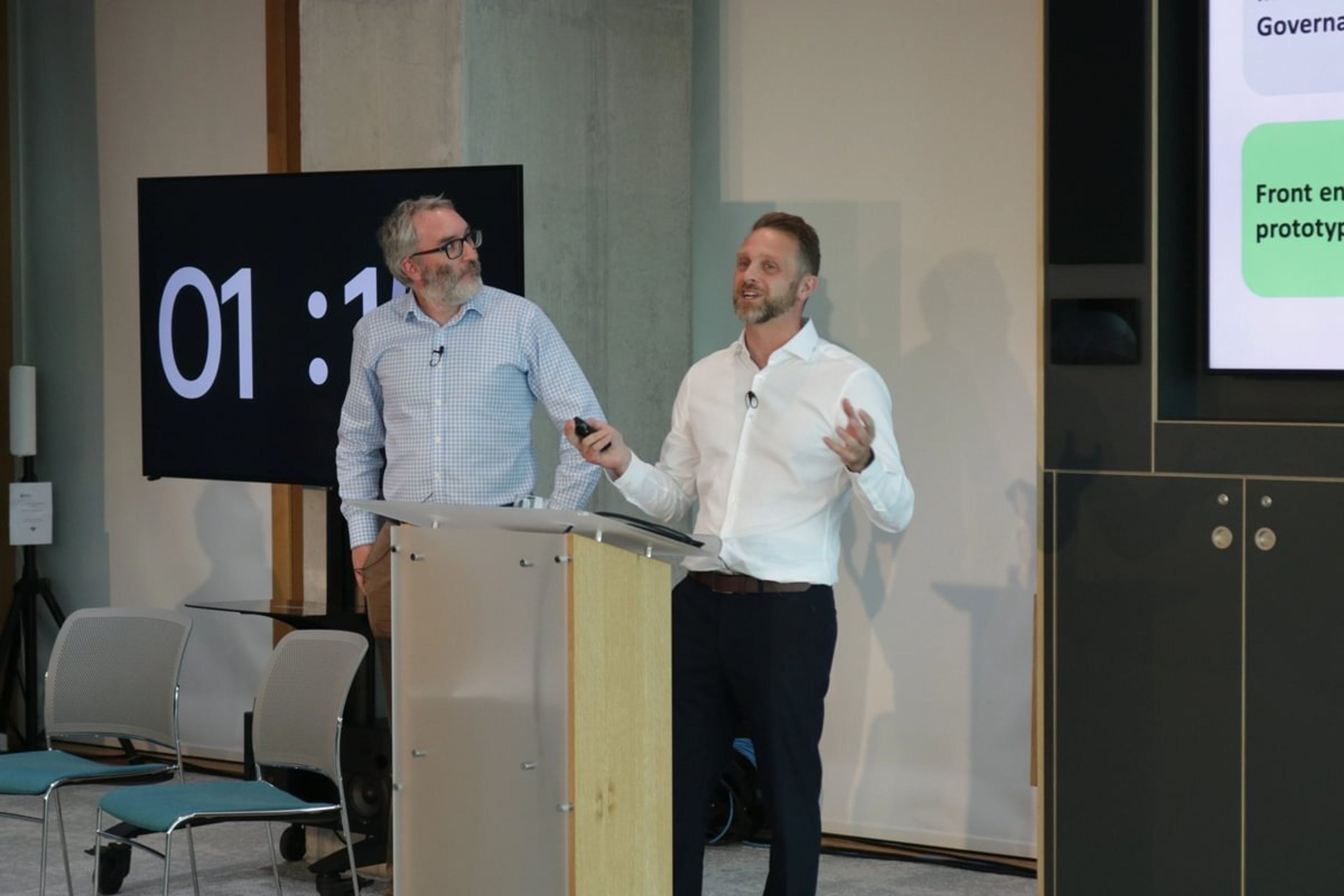 Adam Drage delives his presentation next to Michael Hanks