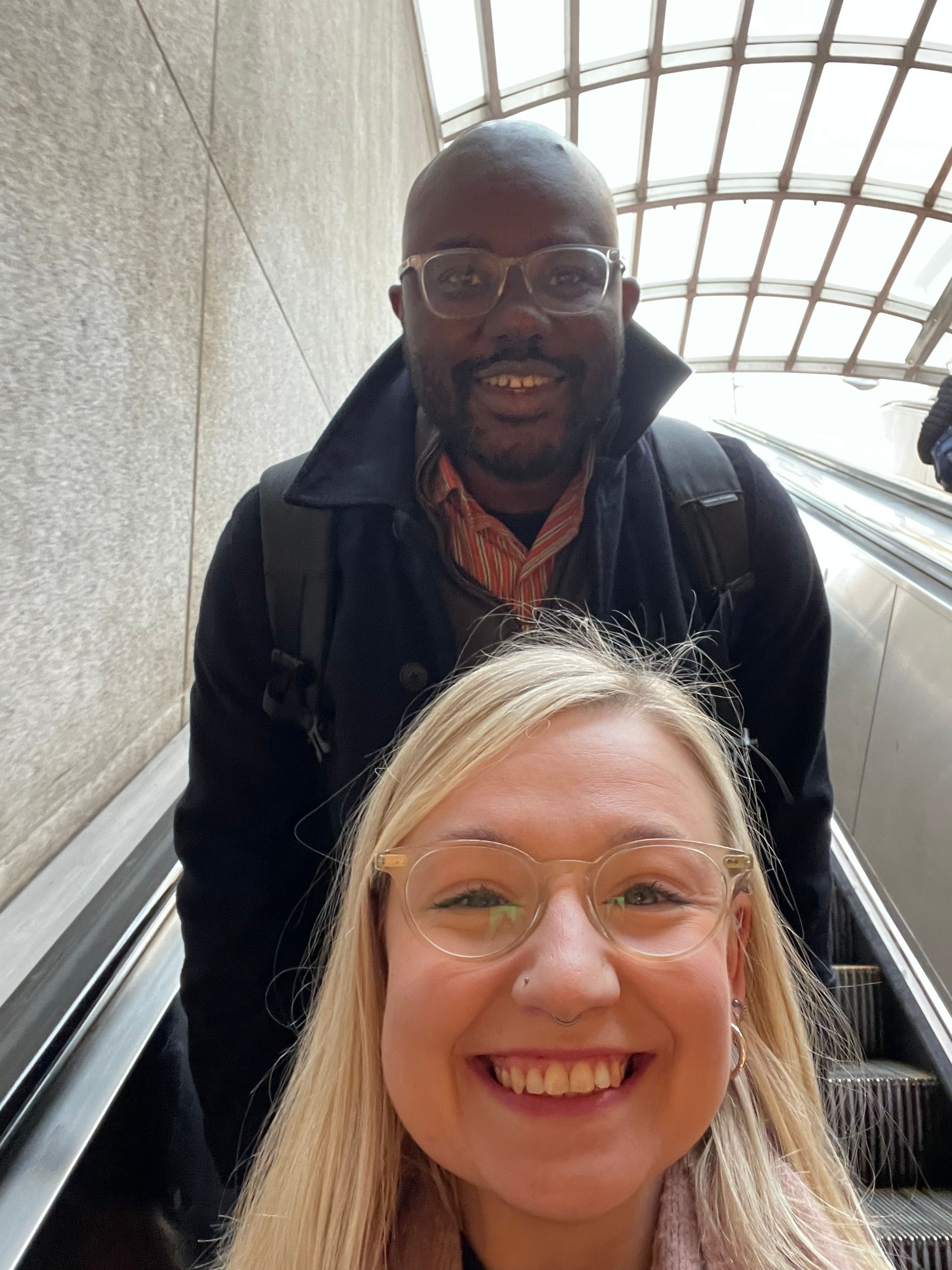 A man and a woman take a selfie in an escalator