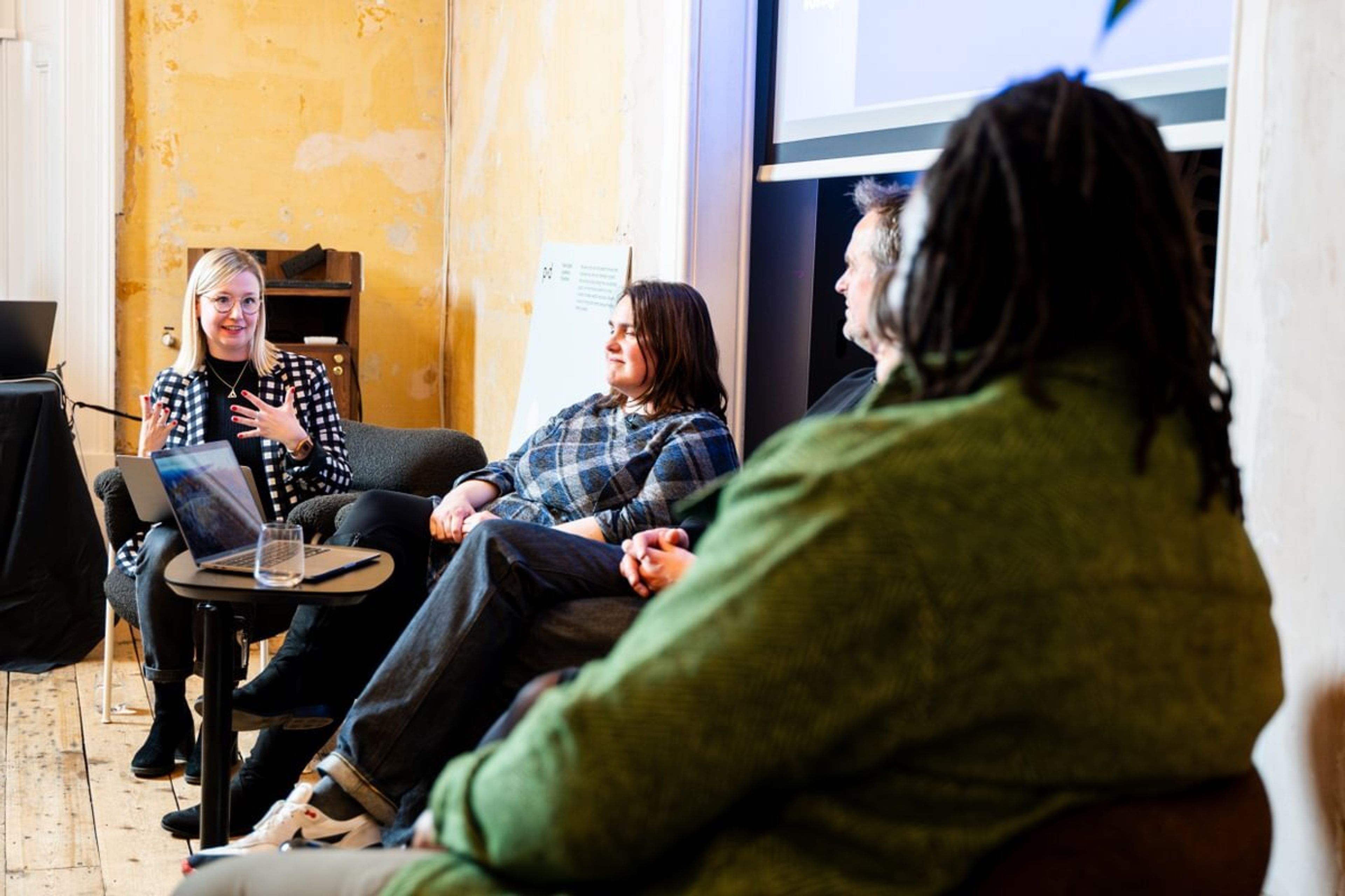 A woman is addressing the rest of the panel she is part of during a talk