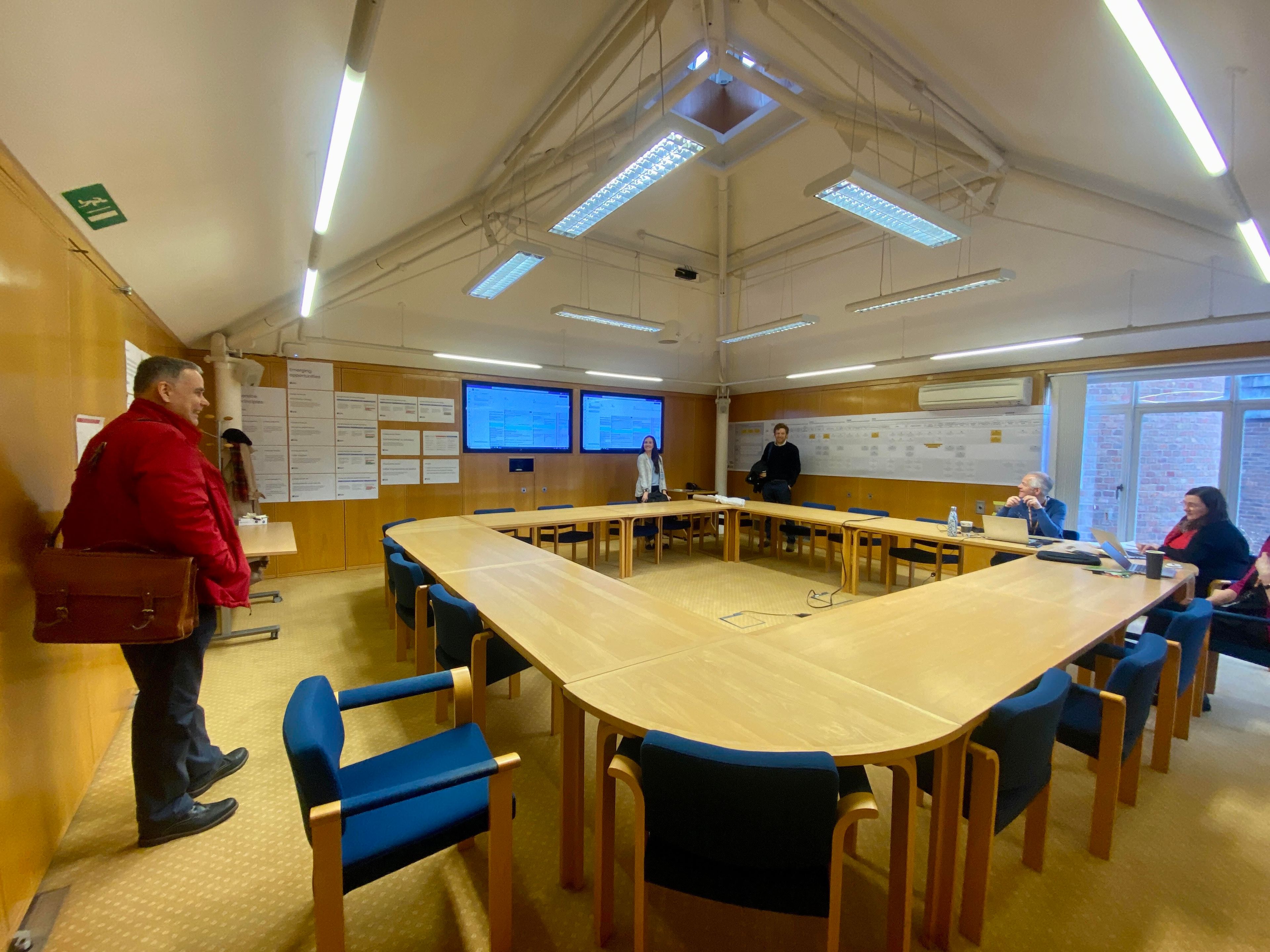 The team working with an education client in a large room required for service mapping