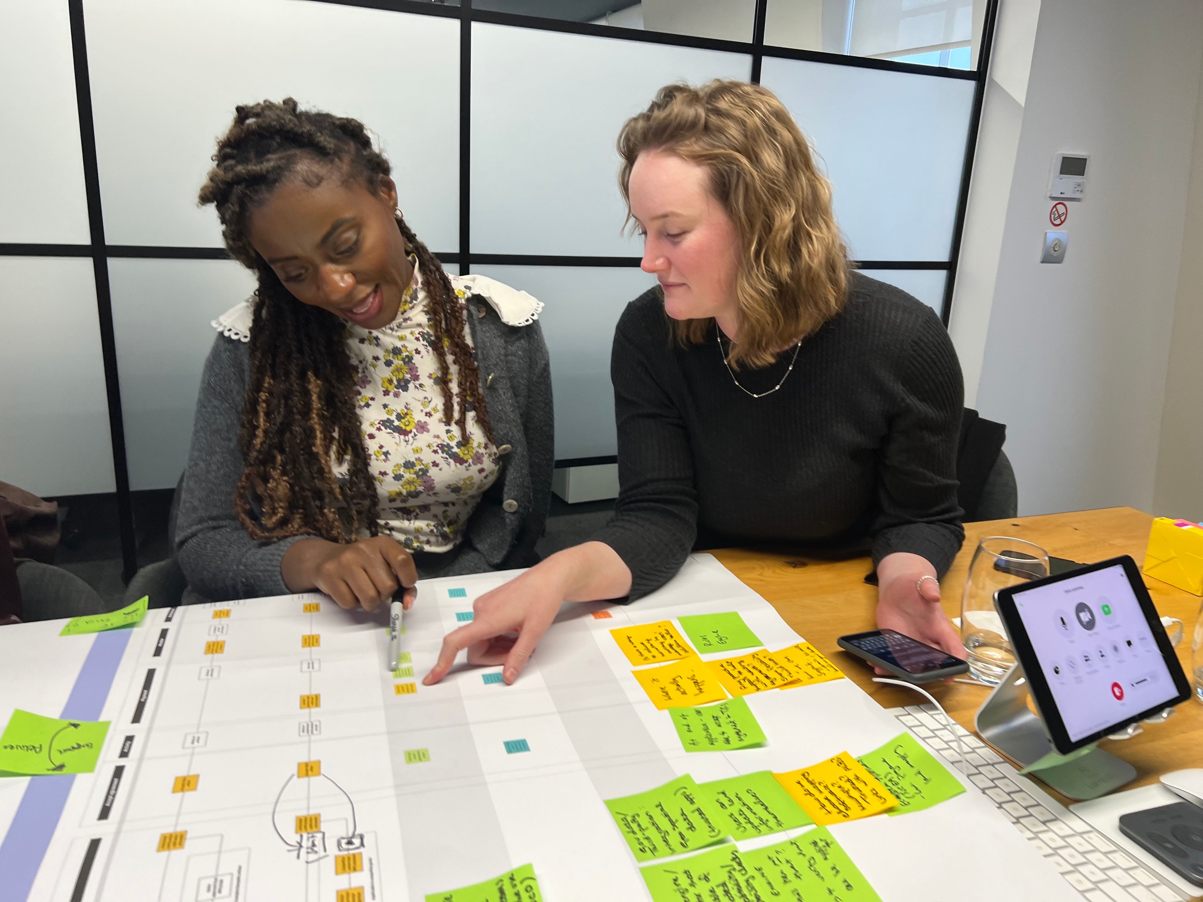 Two clients reviewing a map of services on a large piece of paper
