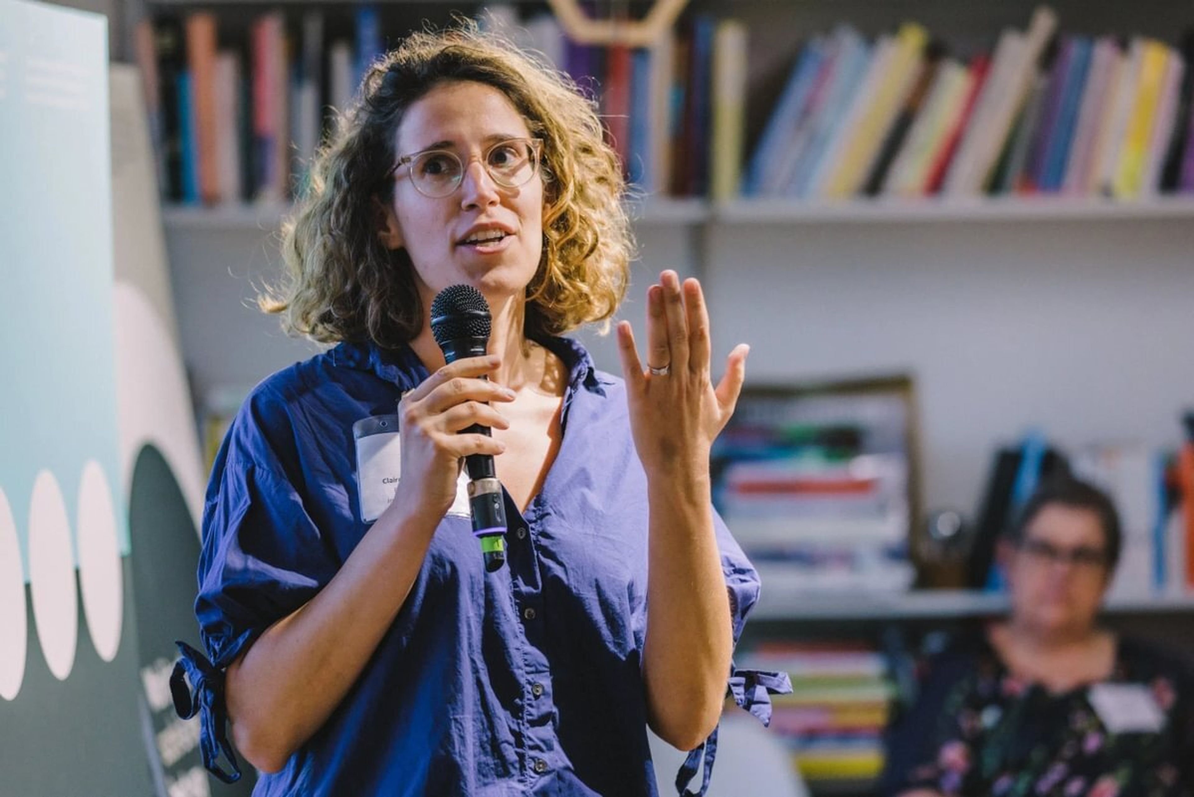 A woman is doing a presentation with a microphone in her hand