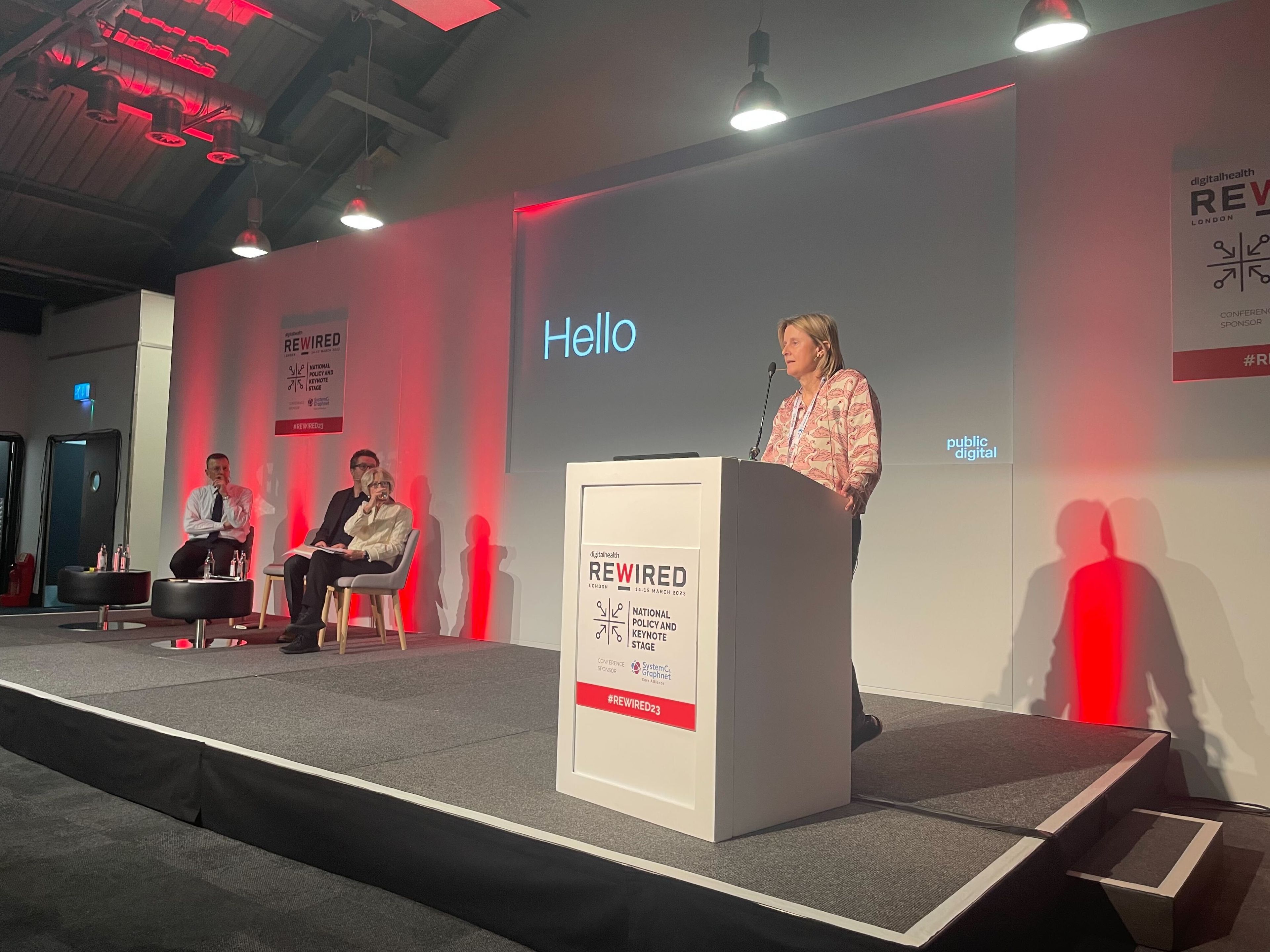 A woman delivering a presentation in a conference