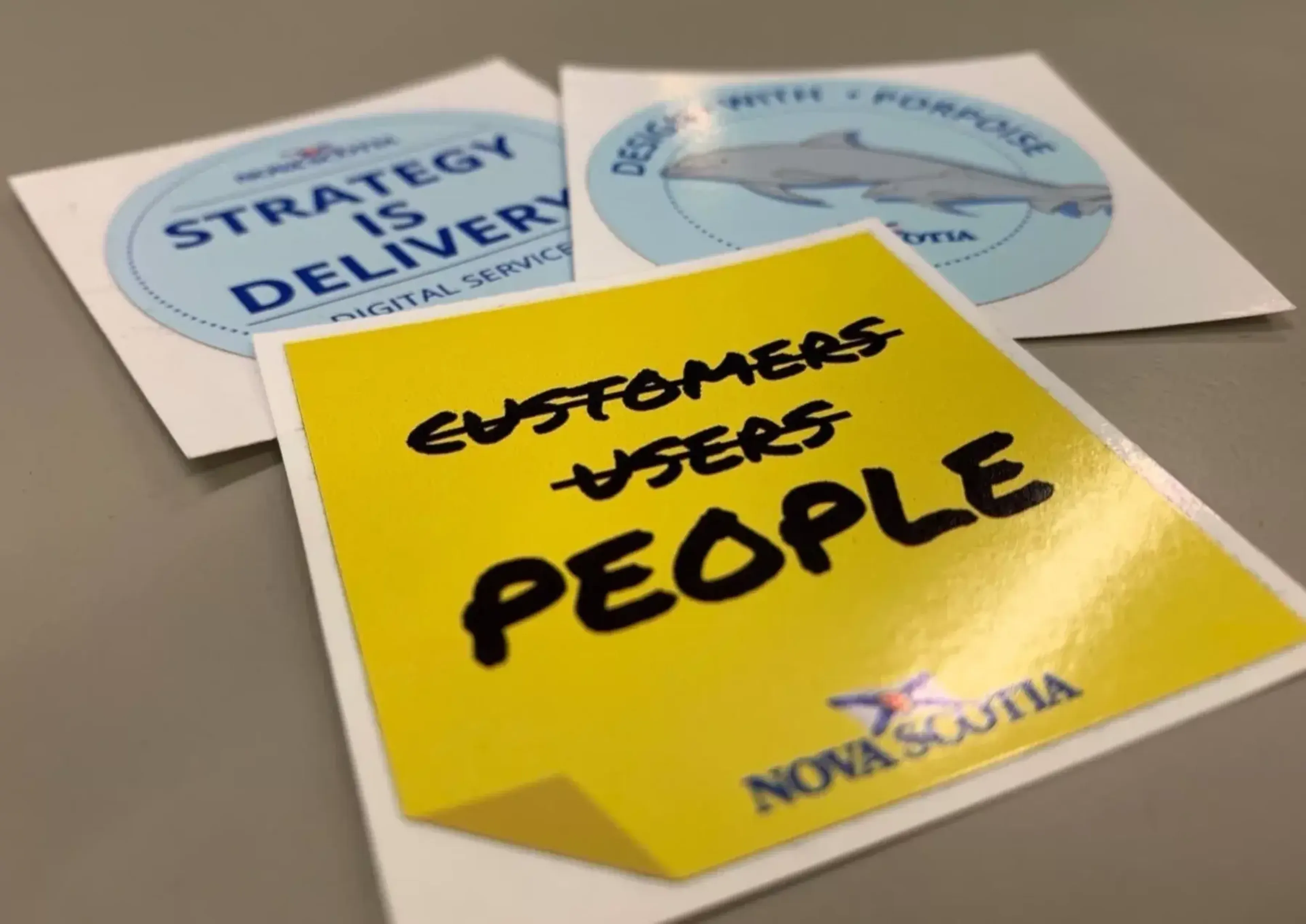 Stickers with statements such as "strategy is delivery" and "people before users and customers"