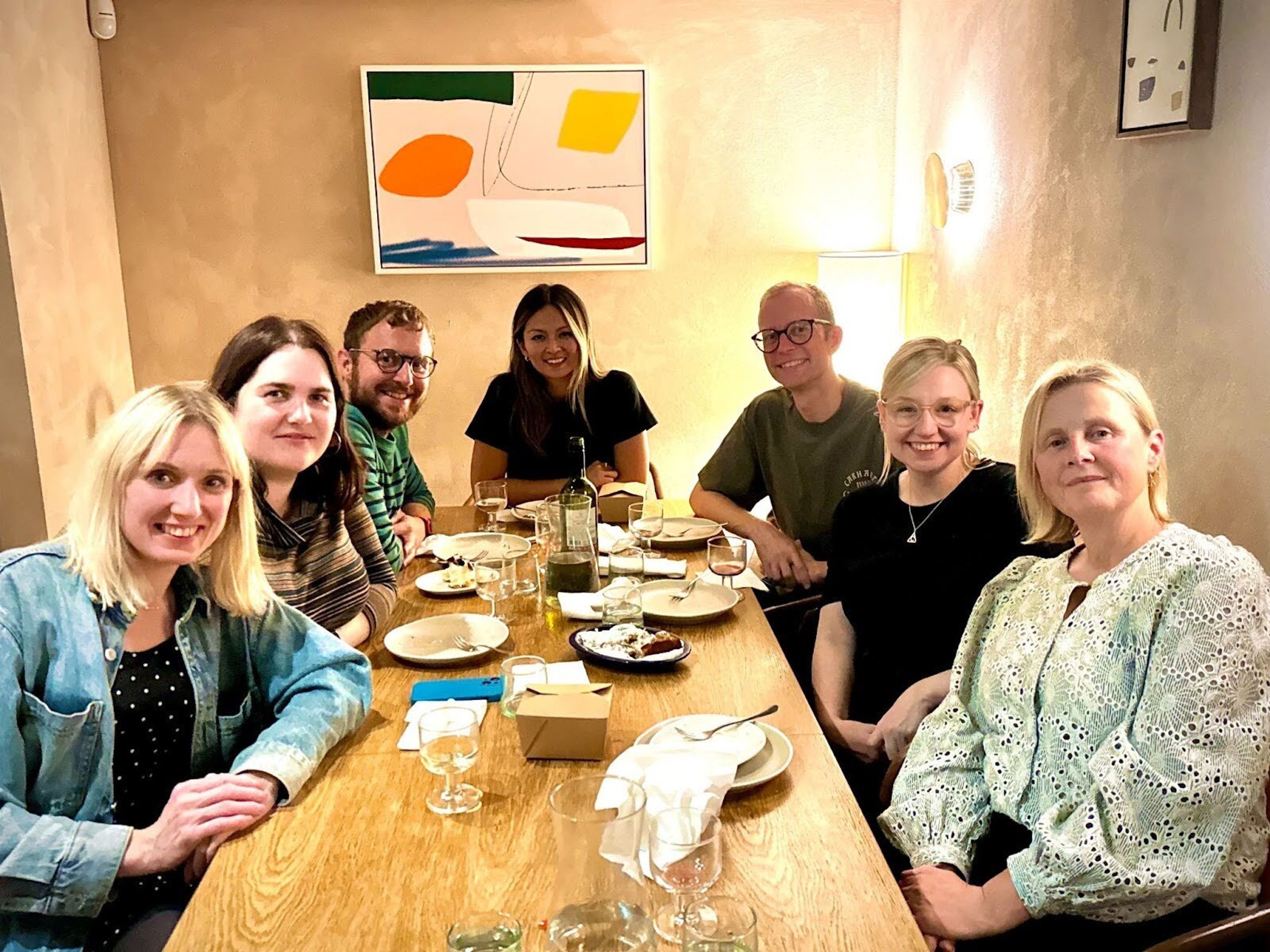 Seven members of the team gather around the table of a restaurant