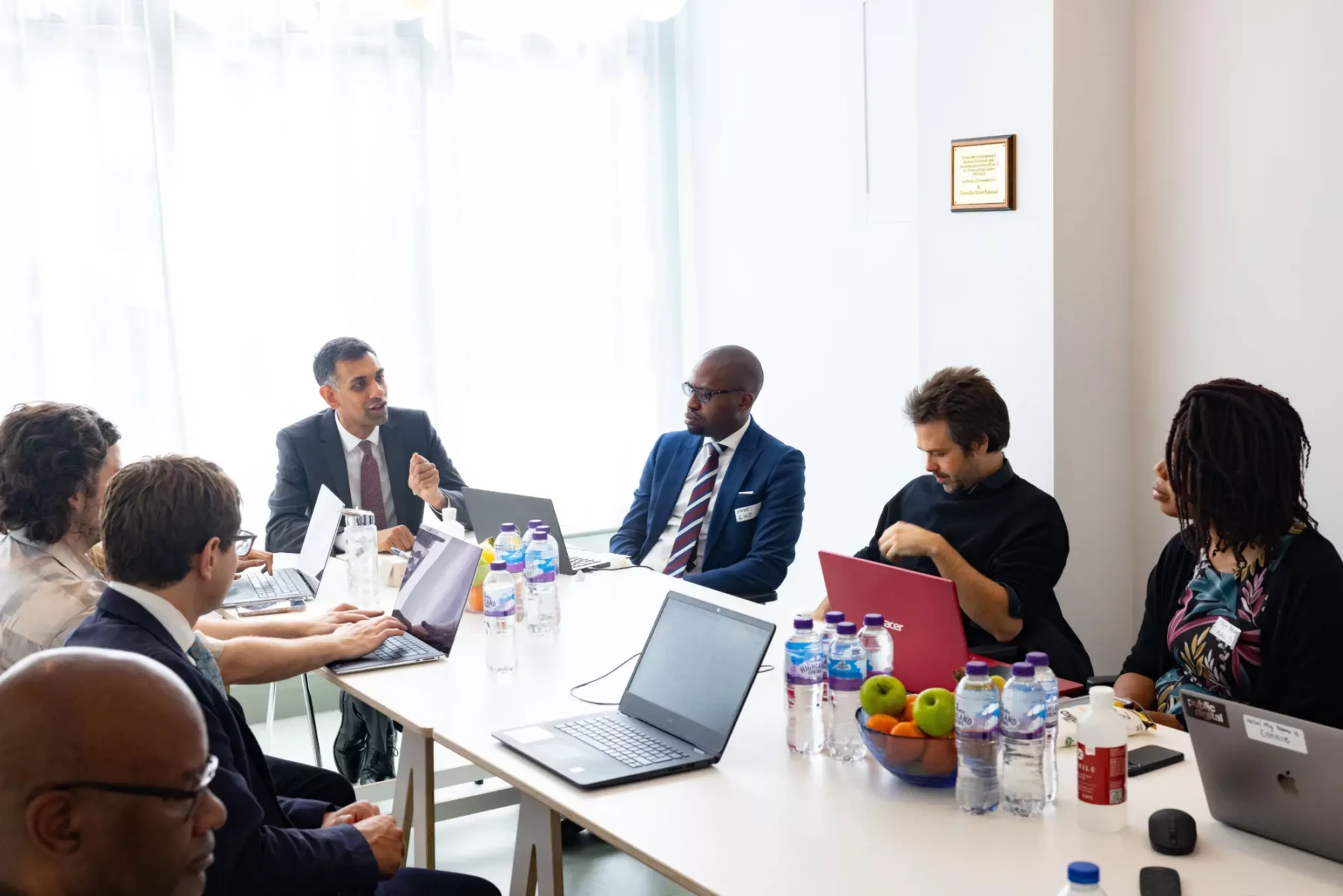 A photograph of some of the members of the sickle cel team, sitting across a table engaged in conversation